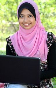 Beautiful muslim woman using laptop while sitting relaxed